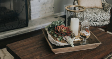 Cozy modern living room featuring a rustic solid wood coffee table, farmhouse-style chairs, and natural textures that blend traditional warmth with contemporary comfort.
