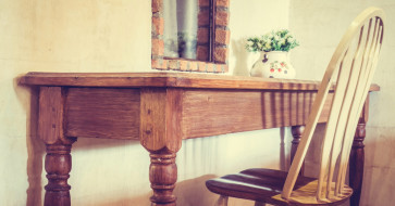 Rustic wooden dining table with natural grain details, showing the timeless charm and warmth of rustic furniture in 2025.